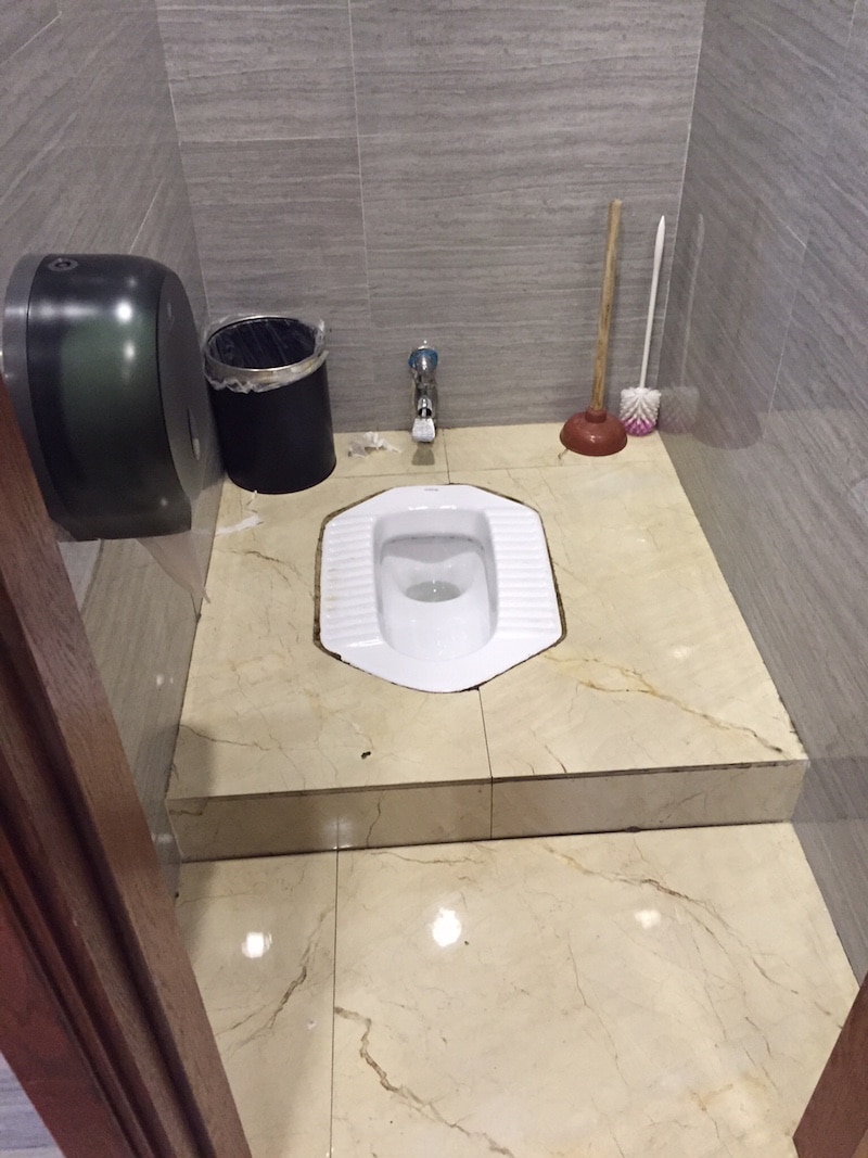 Public Chinese toilets are flat on the ground