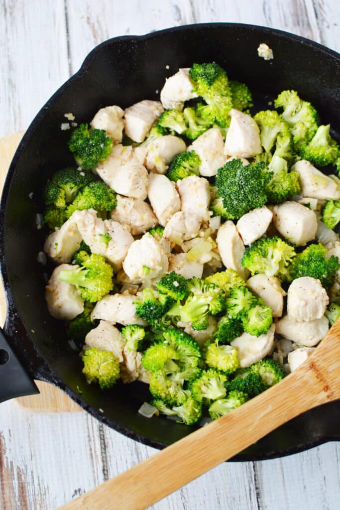 broccoli, onions and garlic with chicken in skillet