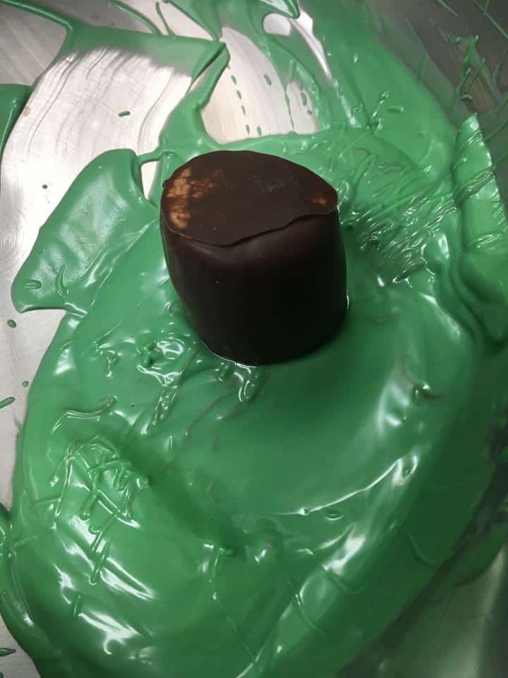 dip marshmallow into melted chocolate using a toothpick