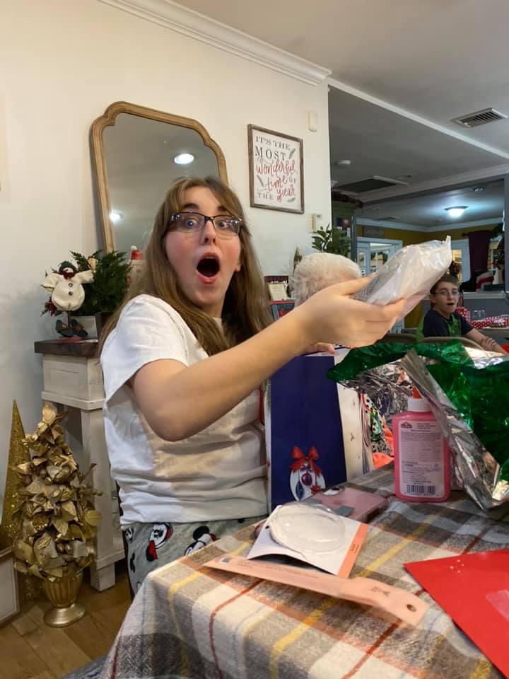 surprised teen opening up presents christmas morning